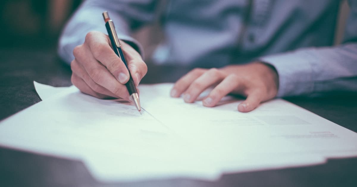 Person signing caravan insurance documents at a desk